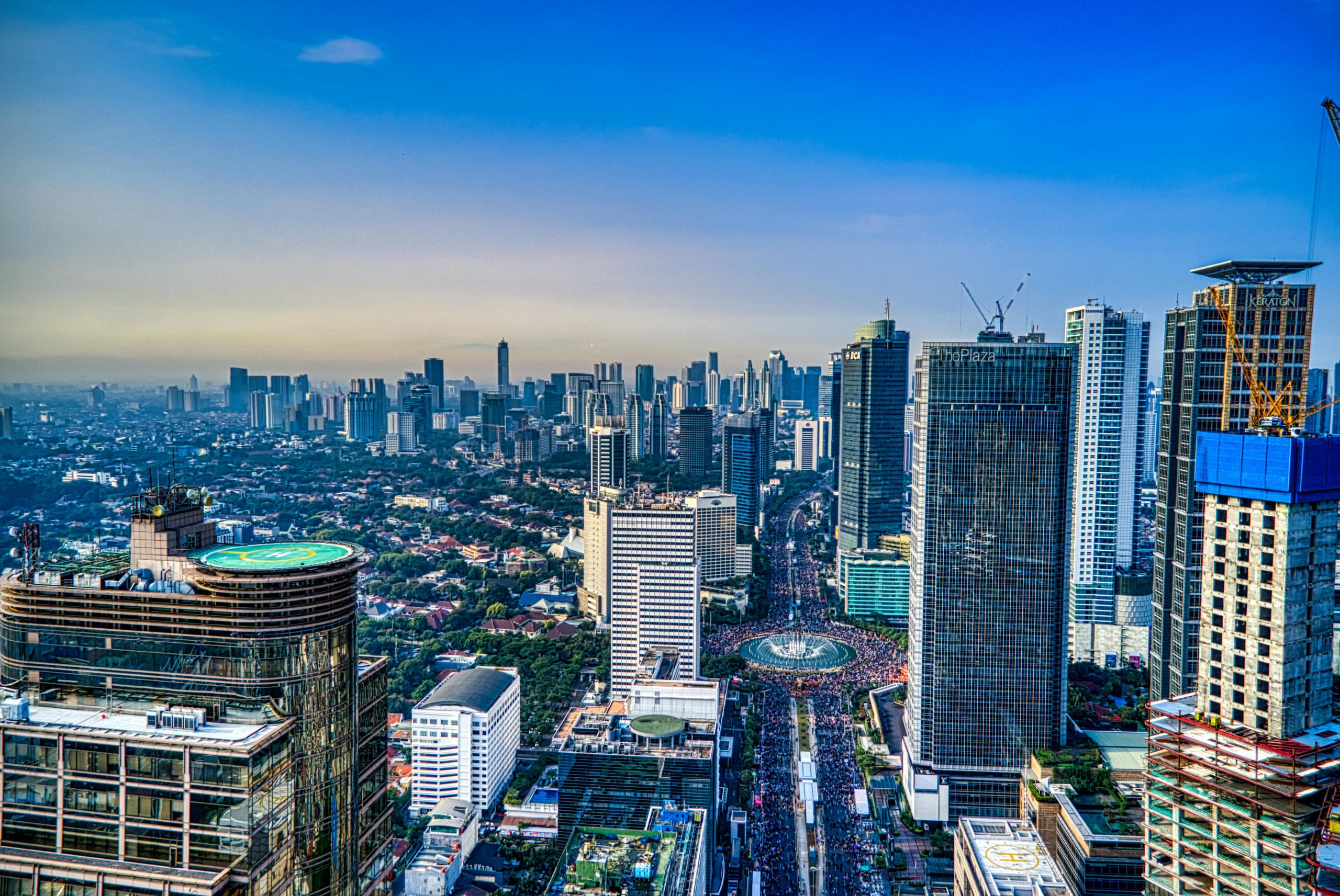 A breathtaking aerial view of Jakarta's urban skyline during the day, showcasing skyscrapers and city life.